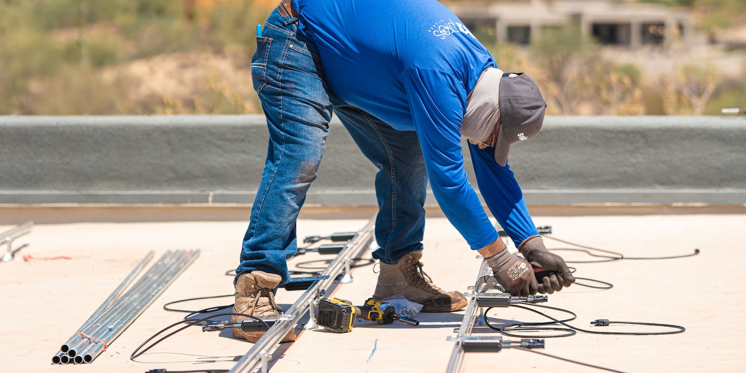 a solar pros worker arranging various parts of a solar panel system