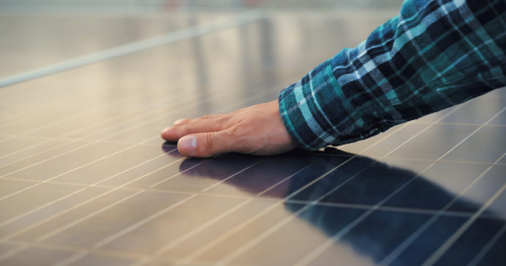 a man understanding solar panel output by touching solar pros installed solar panel