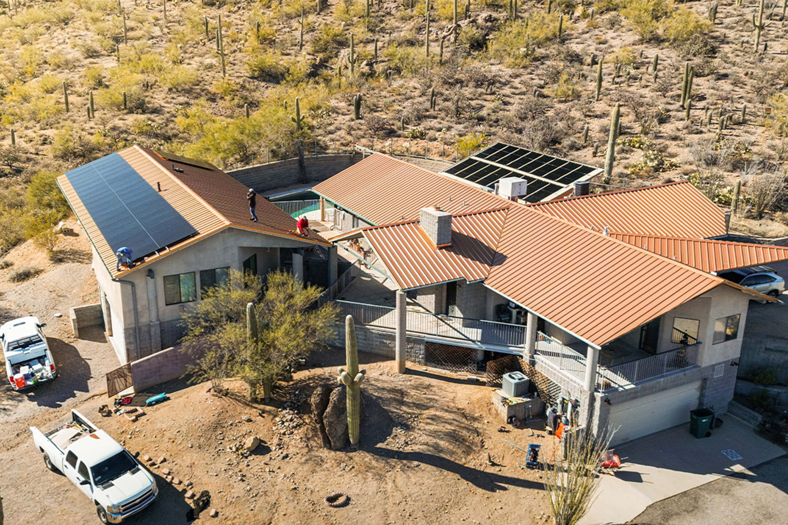 Aerial view of a modern desert home with solar panels on the roof