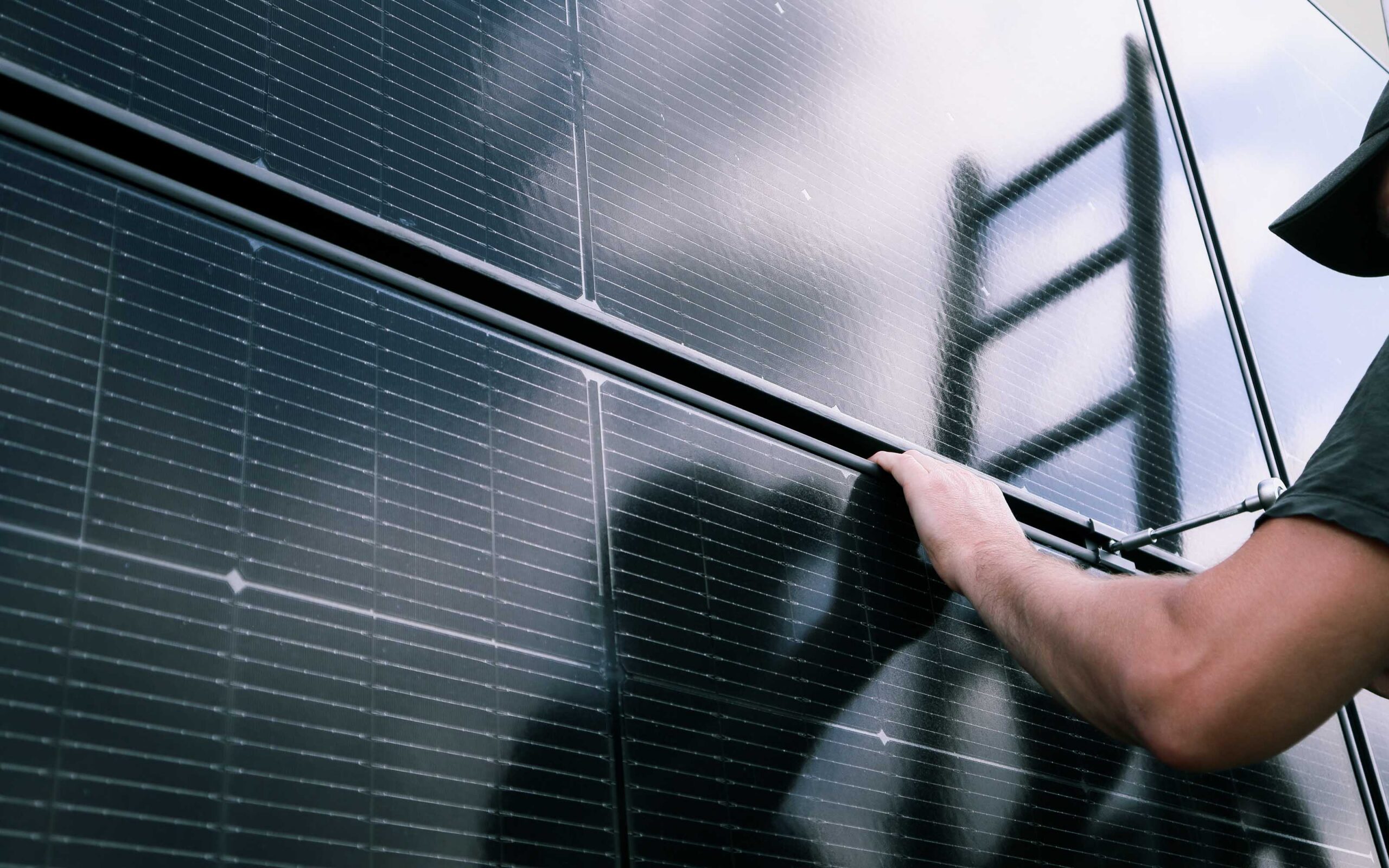 Solar technician inspecting solar panels on a rooftop, illustrating the 20% rule for solar system sizing and installation.